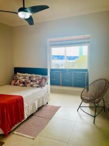 インダイアトゥーバにあるEm frente ao Polo Shoppingのベッドと椅子と窓のある寝室