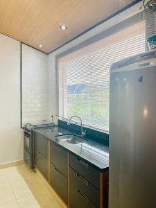 インダイアトゥーバにあるEm frente ao Polo Shoppingのシンクと大きな窓のあるキッチン