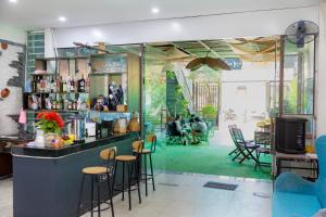 a bar with stools in a room with people at MiChoc Homestay - Hostel in Ninh Binh