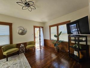 a living room with a flat screen tv and chairs at Cozy Craftman Cottage in Quiet Historic Vallejo Neighborhood in Vallejo