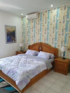 a bedroom with a large bed and two night stands at Amjad5 in Cipanas