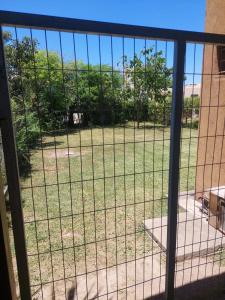 a view of a field of grass through a fence at Lo de nina in Miramar