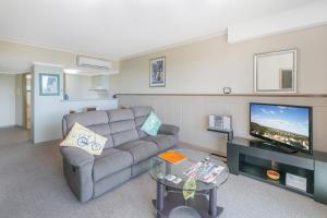 a living room filled with furniture and a tv at Argyle on the Park in Maroochydore