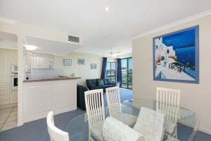 a kitchen and living room with a glass table and chairs at Argyle on the Park in Maroochydore