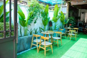 a patio with tables and chairs and plants at MiChoc Homestay - Hostel in Ninh Binh