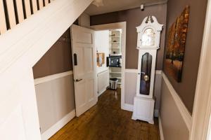 a hallway with a grandfather clock in a house at Hullidays University 2 Bed Ground Floor Apartment in Hull +10 photos