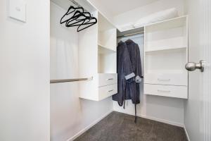 un vestidor con armarios blancos y una puerta en Auckland ONE Tree Hill Coby Suite, en Auckland 10 fotos más