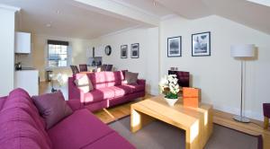 a living room with a purple couch and a table at Destiny Scotland - Princes Street Residence in Edinburgh