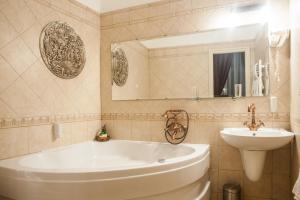 een badkamer met een wit bad en een wastafel bij Cotton House Hotel Budapest in Boedapest