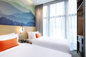 a hotel room with two beds and a window at Hotel YX Lai Chi Kok in Hong Kong
