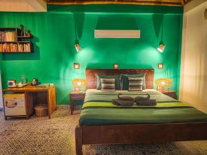 una camera verde con un letto con una parete verde di Au Cabaret Vert a Battambang