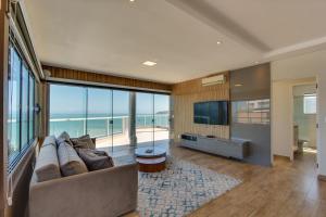 フロリアノポリスにあるImigrantes Apart Hotelのソファとテレビのあるリビングルーム