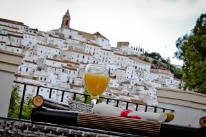 a glass of wine sitting on a railing with a building at Alojamiento Rural El Lario in Alcalá de los Gazules
