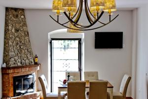 a dining room with a table and a chandelier at Alojamiento Rural El Lario in Alcalá de los Gazules