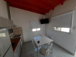 a small kitchen with a white table and chairs at Gotas de Rocio in San Antonio Oeste