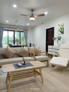 a living room with a couch and a table at Phiratara River House บ้าน พิรธารา ริมแม่น้ำปราจีนบุรี in Ban Suan Phlu