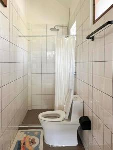 a white bathroom with a toilet and a shower at Phiratara River House บ้าน พิรธารา ริมแม่น้ำปราจีนบุรี in Ban Suan Phlu +18 photos