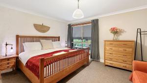 a bedroom with a bed and a dresser and a window at Mount Gibraltar Retreat in Mittagong +16 photos