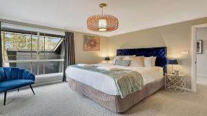 a bedroom with a large bed and a blue chair at Mount Gibraltar Retreat in Mittagong