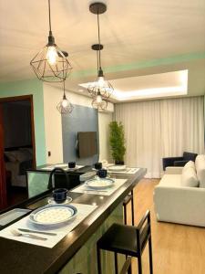 a kitchen and living room with a table and chairs at Flat Rosarinho - Confortável e Super Completo in Recife