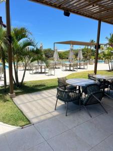 un patio con tavoli, sedie e ombrelloni di Casa Costa do Sauipe- Dentro do Complexo - Reserva sauipe a Mata de Sao Joao