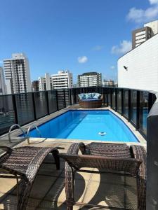 a swimming pool on the roof of a building at Flat Rosarinho - Confortável e Super Completo in Recife