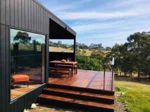 un ponte di legno con un tavolo sul lato di una casa di Architecturally Designed Rural Retreat a Forcett