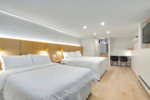 two beds in a hotel room with white sheets at Modern King-Size Guest Suite with AC in Burnaby