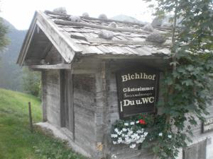 un petit bâtiment avec un panneau sur son côté dans l'établissement Bichlhof Riedenberg, à Thiersee