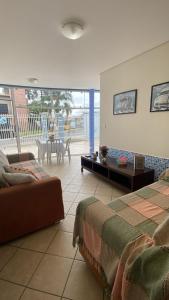 a living room with two beds and a table at Casa do Jardim in Curitiba