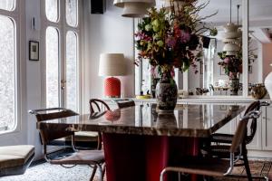 a dining room with a table with a vase of flowers at Le Pigalle, a Member of Design Hotels in Paris
