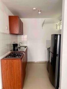 a small kitchen with a stove and a refrigerator at Apartamento en Montenegro cerca al Parque del café in Montenegro