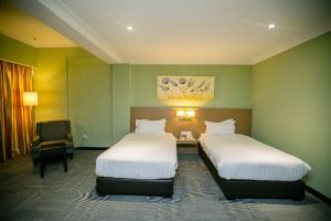 Postel nebo postele na pokoji v ubytování Merdeka Hotel Kluang