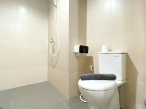 une salle de bain avec des toilettes blanches et une douche dans l'établissement Well Furnished and Cozy Studio at Gateway Park LRT City Jatibening Apartment By Travelio, à Bekasi 12 autres photos