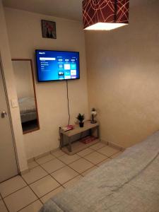 a bedroom with a flat screen tv on the wall at Habitación Pedregal in Rancho de la Cruz