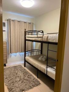 ドゥマゲテにあるR&R Cozy 2BR Marina Dumagueteの二段ベッド2台とラグが備わる客室です。 +14枚の写真
