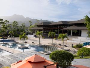 a resort with a pool with palm trees and buildings at Cocoons Club Laiya in Batangas City