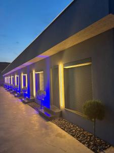 a row of windows on a building with blue lights at Eataly Cazare Bals in Balş
