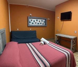 una camera da letto con un letto e una televisione di Casa Eva a Tepoztlán Altre 15 foto