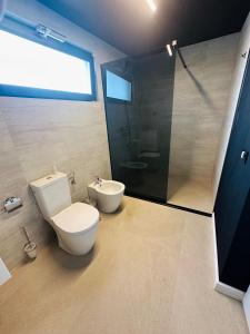 a bathroom with a white toilet and a shower at Eataly Cazare Bals in Balş