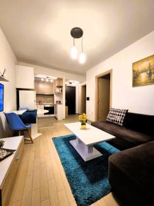 una sala de estar con un sofá y una mesa en Flatiron Royal Apartment, en Skopje