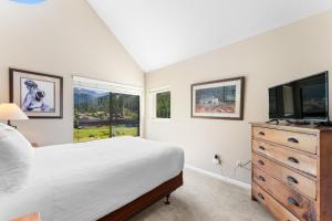 Un dormitorio con una cama y un televisor de pantalla plana. en Greens at Copper 315 by Summit County Mountain Retreats, en Copper Mountain