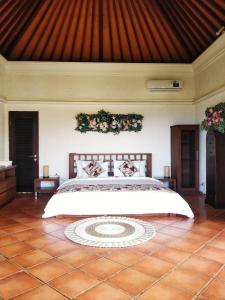 1 dormitorio con 1 cama grande con flores en la pared en The Dharma Araminth Villa - Lovina Mountain and Sea View, en Lovina