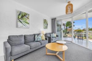 a living room with a couch and a table at The Palms Apartments in Merimbula