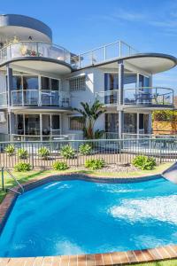 una casa con piscina delante en The Palms Apartments, en Merimbula