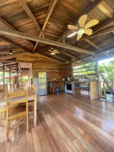 a living room with a table and a ceiling fan at Pangea Lodge Tropical Vibe Home with Shared Pool in Manzanillo