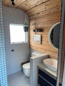 a bathroom with a toilet and a sink at Electric Waihi Beach House - family & dog friendly, close to beach, pool table, outdoor fire room, skate ramp in Bowentown
