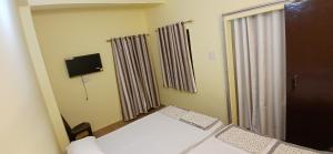 Habitación con 2 camas y ventana con cortinas. en Incredible Banaras Inn, en Varanasi