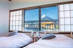 Postel nebo postele na pokoji v ubytování Fujiクロスゲートハウス 離 -HANARE-