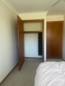 an empty room with a bed and two open doors at Elegant Castlehill Stay in Castle Hill